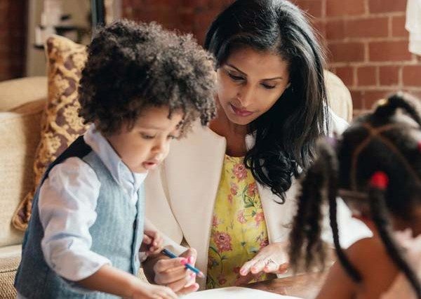 a mother drawing with a young son and daughter