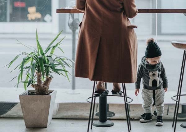 a mother in a long trench coat with her toddler son