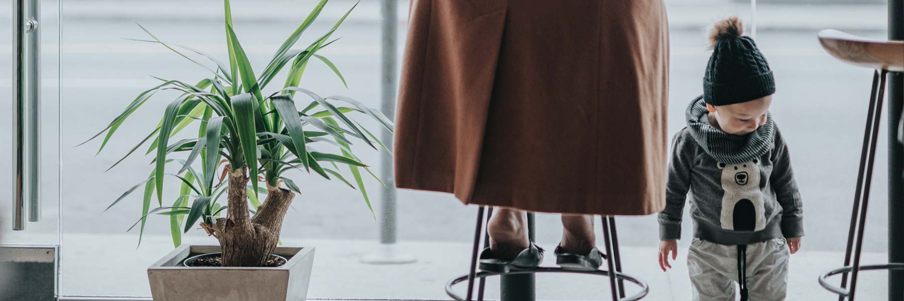 a mother in a long trench coat with her toddler son