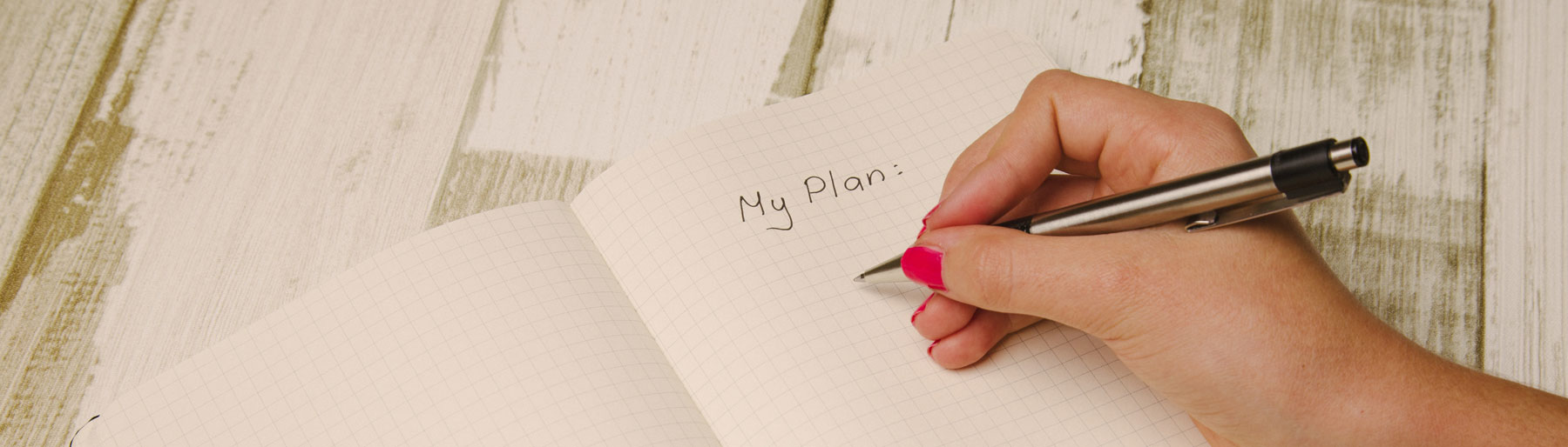 woman writing in a note pad "My Plan"